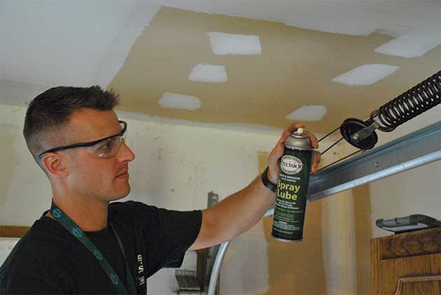 Technician Lubricating Extension Springs